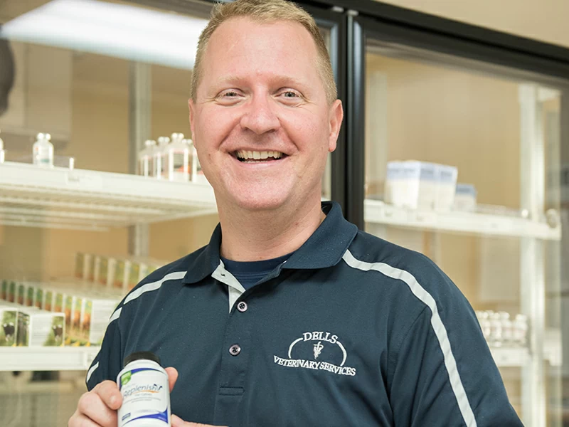 Photo of Daniel Dorn, Dells Veterinary Services, Dell Rapids, SD, holding a bottle of BlueLite Replenish M