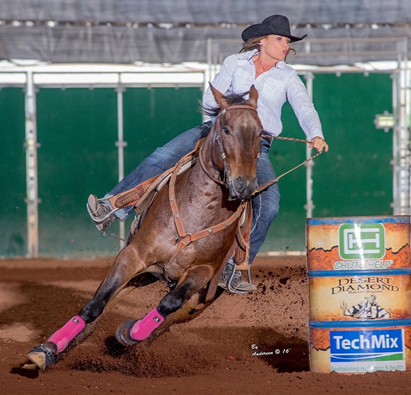 Photo of a rider taking a horse around a competition barrel